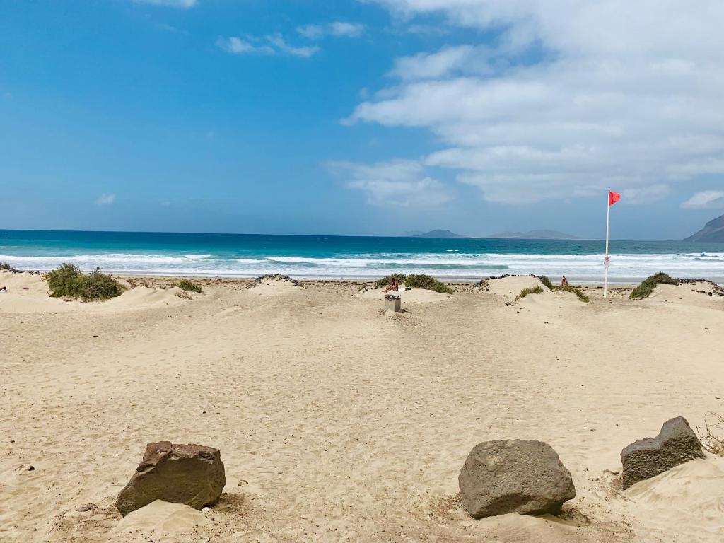 una persona parada en una playa con rocas en la arena en FCG24a, en Famara