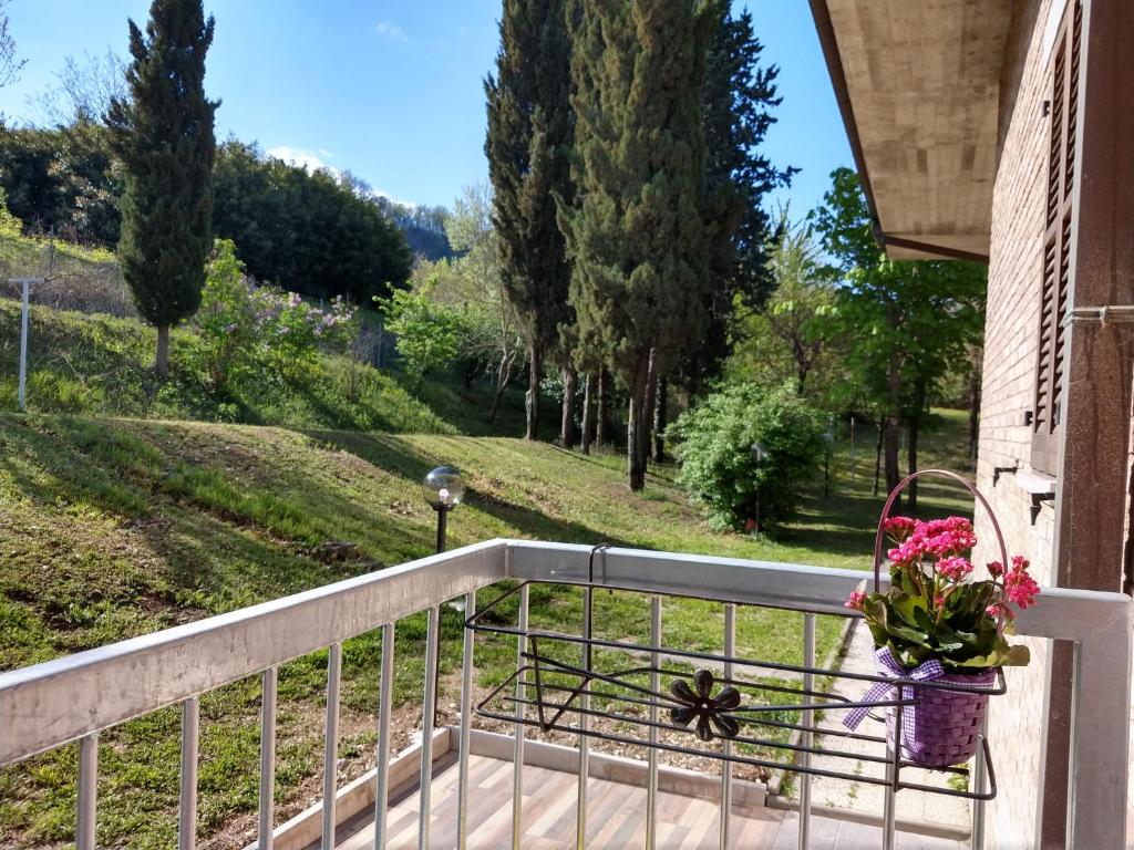 un balcón con flores en una cesta en una casa en B&B IL TORCHIO-URBINO, en Urbino