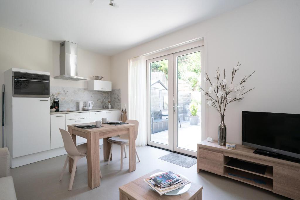 sala de estar con mesa y cocina en Santvort Luxury Apartment with Private Parking, en Zandvoort