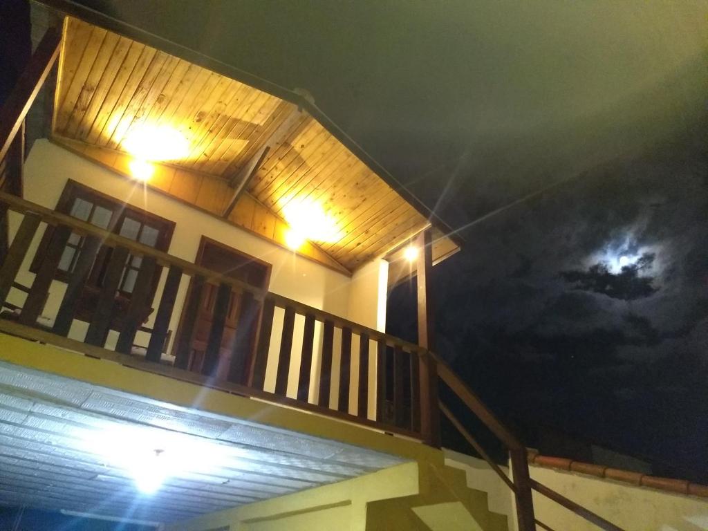 Chalés Luz da Montanha في Núcleo Mauá: منزل مع شرفة مع قمر في السماء