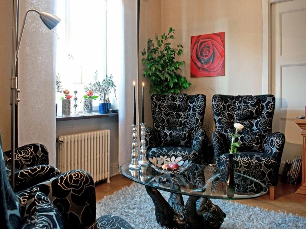 uma sala de estar com duas cadeiras e uma mesa de vidro em Eklanda Bed & Breakfast em Gotemburgo