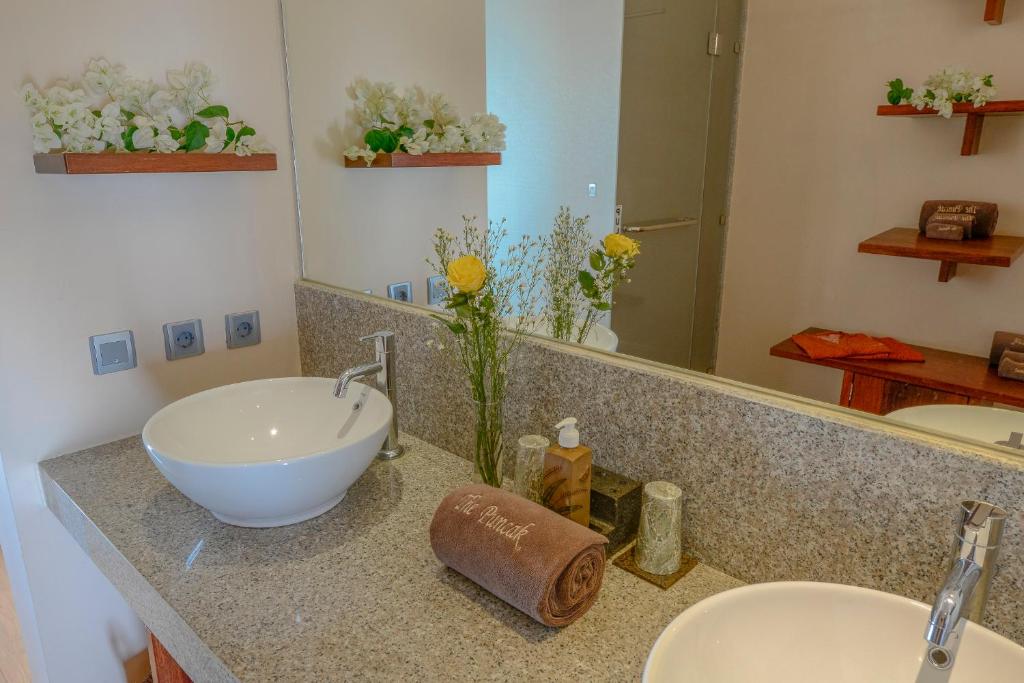 a bathroom with two sinks and a large mirror at The Puncak Lombok in Senggigi