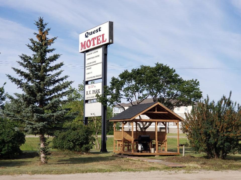 a sign for a sweet motel with a gazebo at Quest Motel in Whitewood