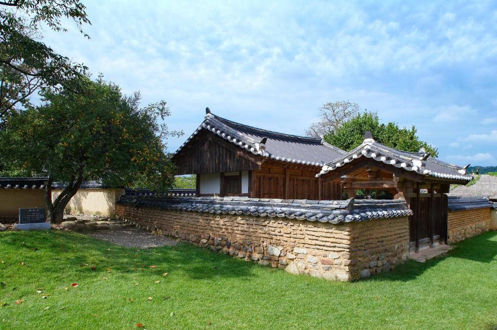 un edificio con una pared de piedra en un patio en Bukchondaek, en Andong