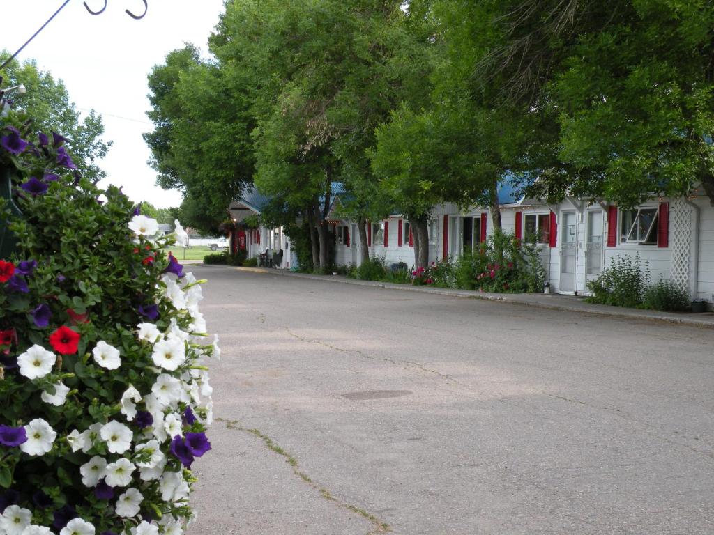 a street with a row of houses and flowers at Bluebird Motel in Claresholm