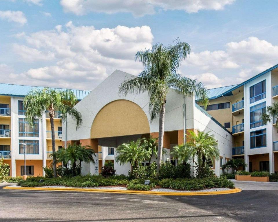 a building with palm trees in front of a parking lot at Comfort Inn Naples East I-75 in Naples