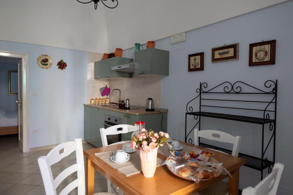 a kitchen with a wooden table with flowers on it at Dimora del Murattiano in Monopoli