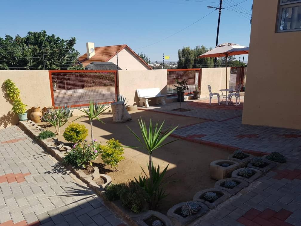 un patio con un banco y plantas en un patio en Emerald Bed&Breakfast, en Windhoek