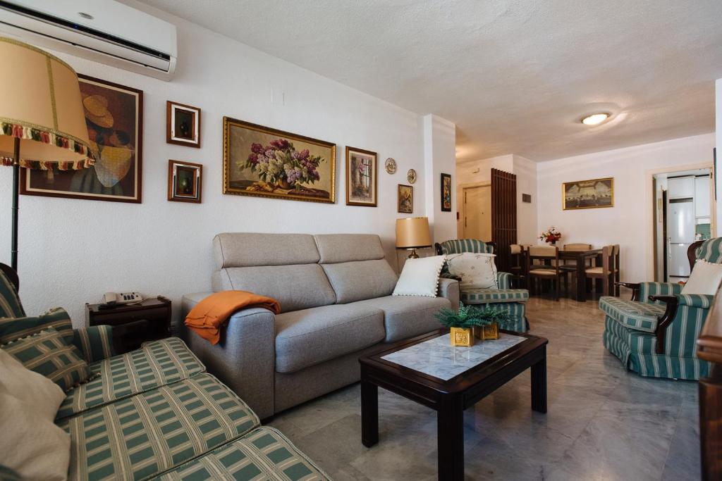 een woonkamer met een bank en een tafel bij luminoso piso nervion in Sevilla