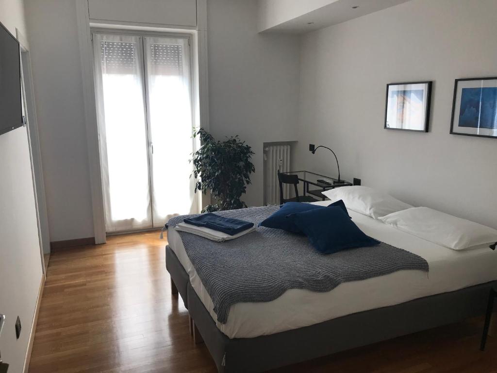 a bedroom with a bed with blue pillows on it at Feel@Home Apartment+Rooms in Milan