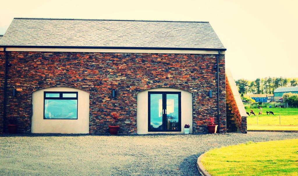 a brick building with two windows on a field at Heathery Hill in Belfast