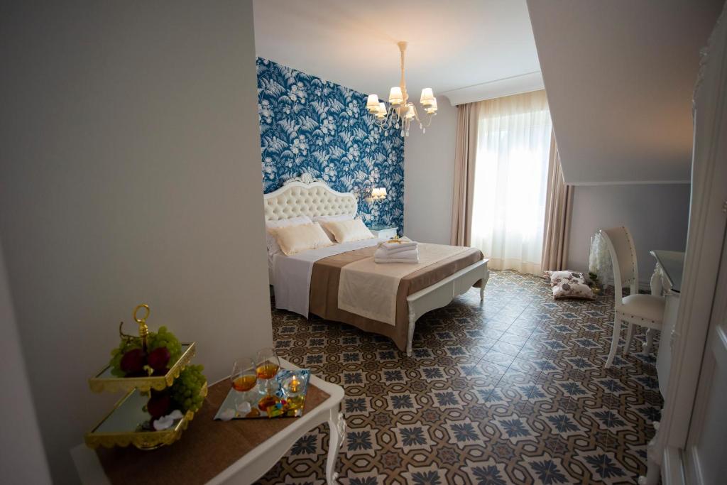 a bedroom with a bed and a table in a room at Sui Generis Tropea Luxury Rooms in Tropea