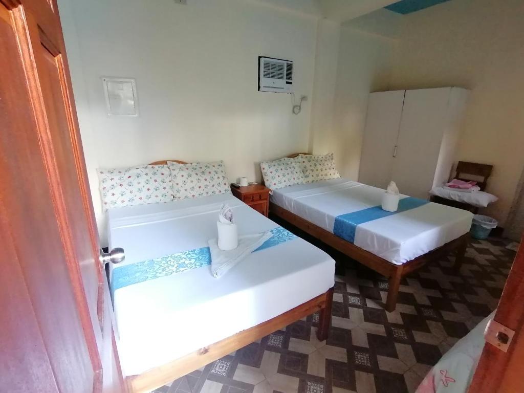 a room with two beds in a room at Mariner's Pension House in Puerto Princesa City