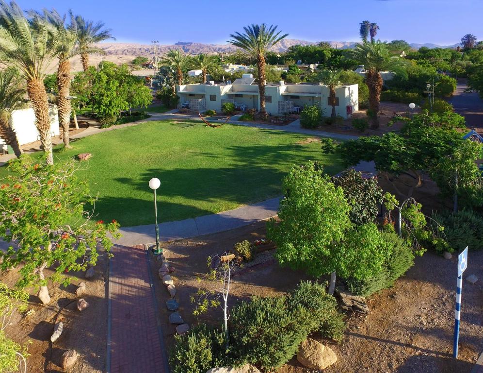 een luchtzicht op een tuin met palmbomen en huizen bij Eilot Kibbutz Country Lodging in Eilat