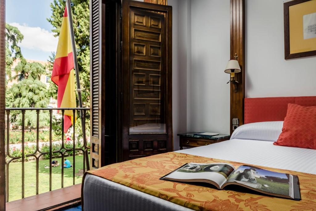 a bed sitting in front of a window in a bedroom at Hotel El Bedel in Alcalá de Henares