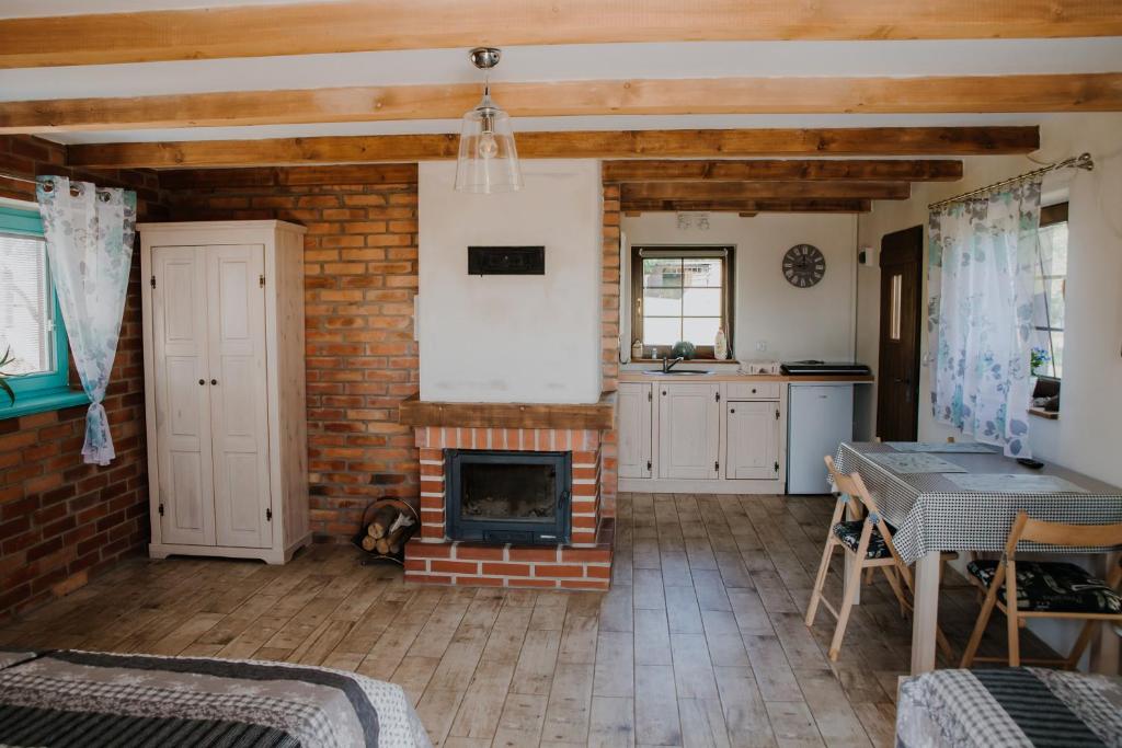 uma sala de estar com uma lareira de tijolos e uma mesa em Ranczo Okole em Świerzawa