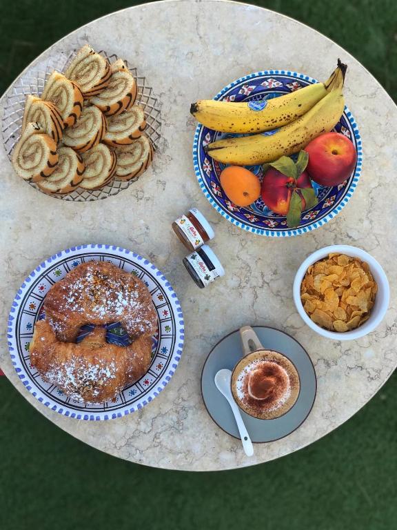a table topped with plates of food and fruit at Villa Pollio Guest House in Anacapri