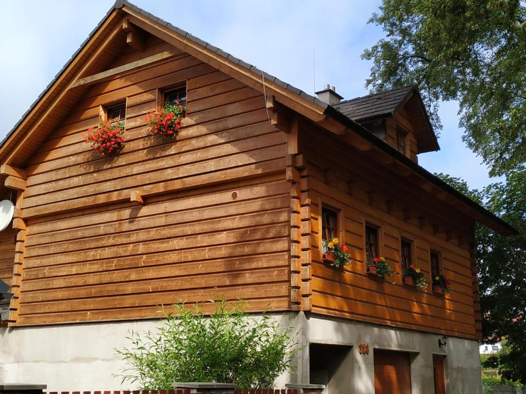 ein Holzhaus mit zwei Fenstern und Blumen darauf in der Unterkunft U Jolany in Svoboda nad Úpou