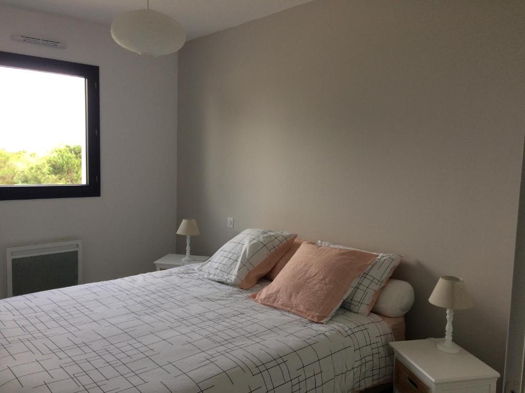 a bedroom with a bed with two lamps and a window at Villa avec piscine privée, vue sur mer et plage à pied 800m in Saint-Jean-de-Luz