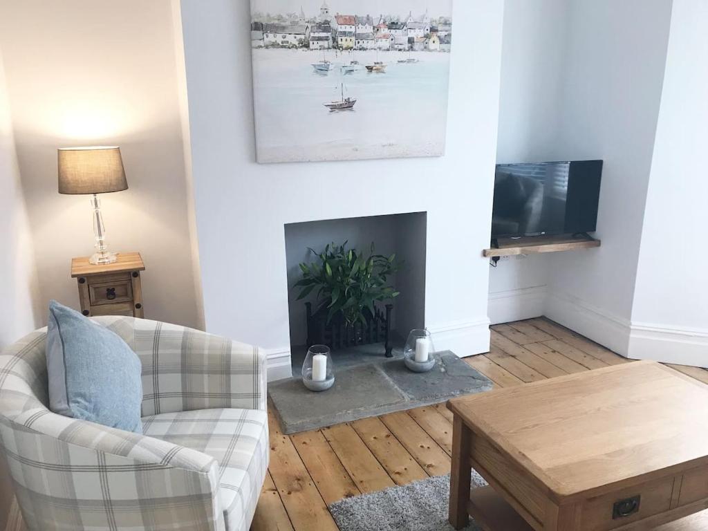 a living room with a couch and a fireplace at 143 New Road Porthcawl in Porthcawl