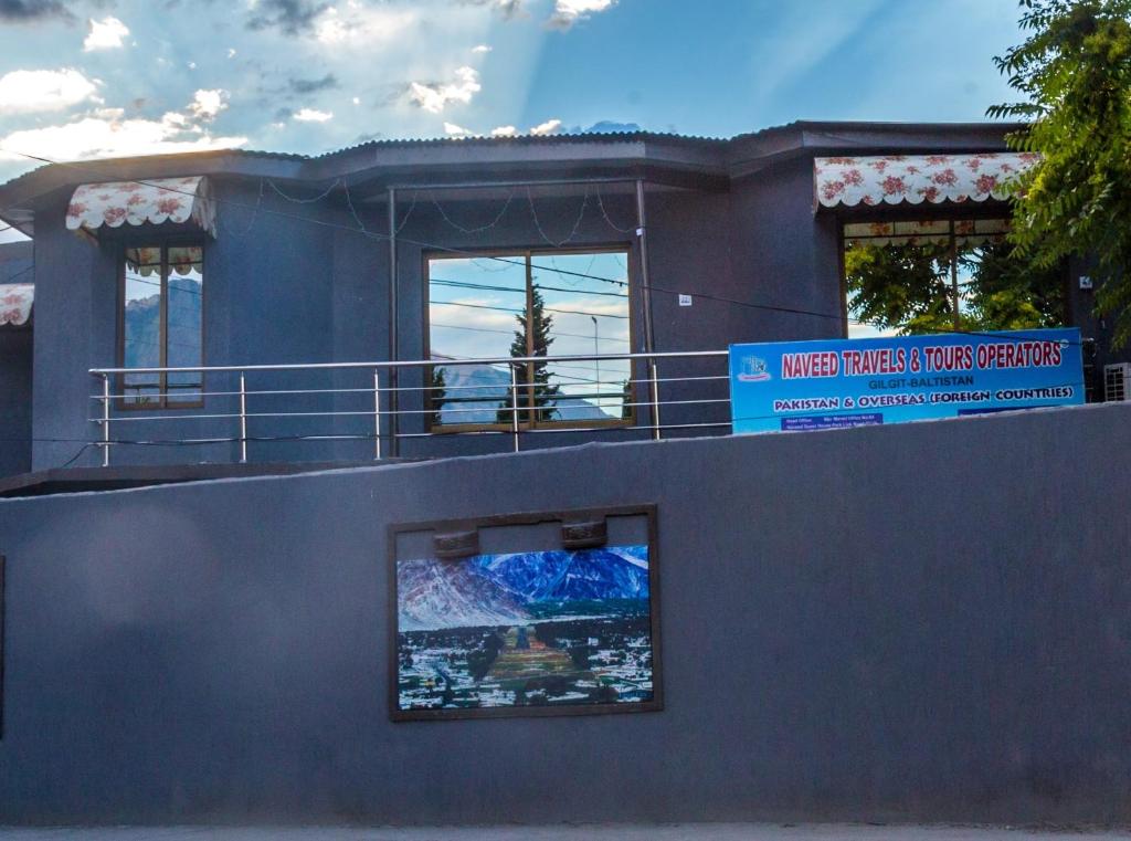 une maison avec un panneau en haut dans l'établissement Naveed Tourist Inn, à Gilgit