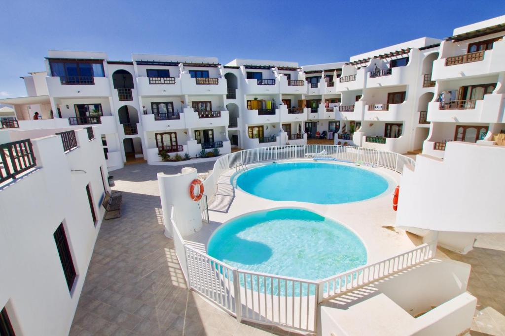 arial view of a building with a swimming pool at APARTMENT GOLDEN costa teguise in Costa Teguise