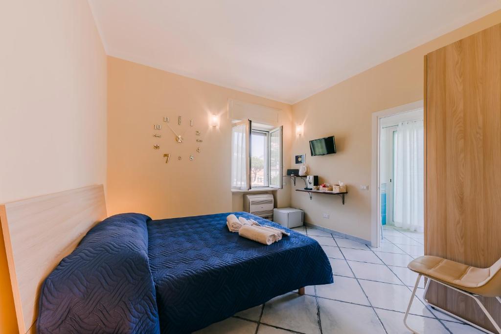 een slaapkamer met een blauw bed en een klok aan de muur bij Peppa Room in Ravello