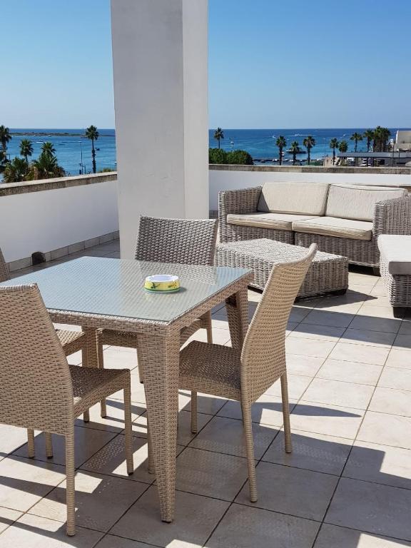 a table and chairs on a patio with the ocean at Appartamenti vista Mare in Porto Cesareo