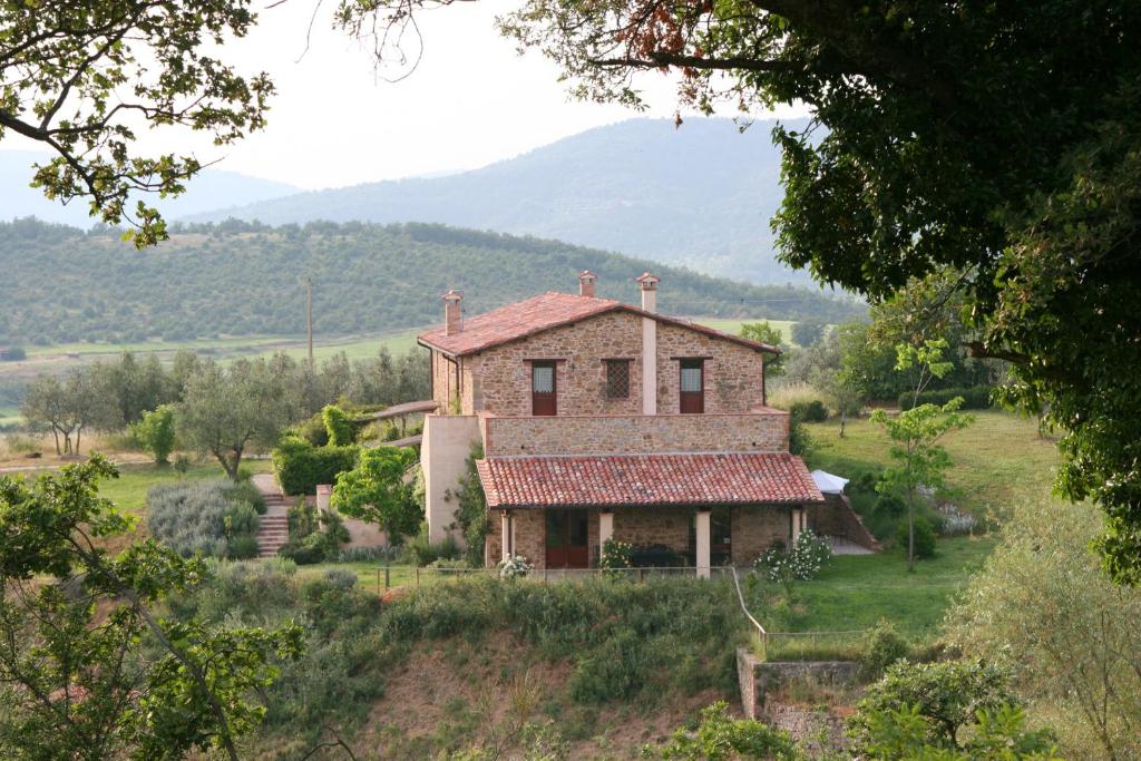 una vieja casa en una colina en un campo en La Casa Di Piandelbello, en San Venanzo