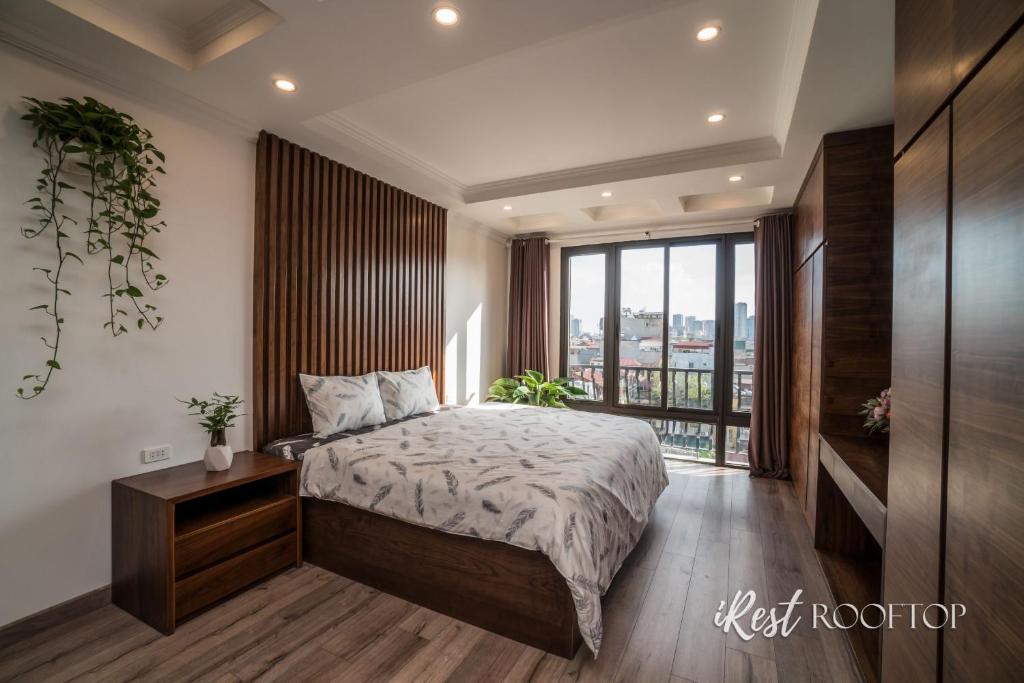 a bedroom with a bed and a large window at Irest Apartment in Hanoi