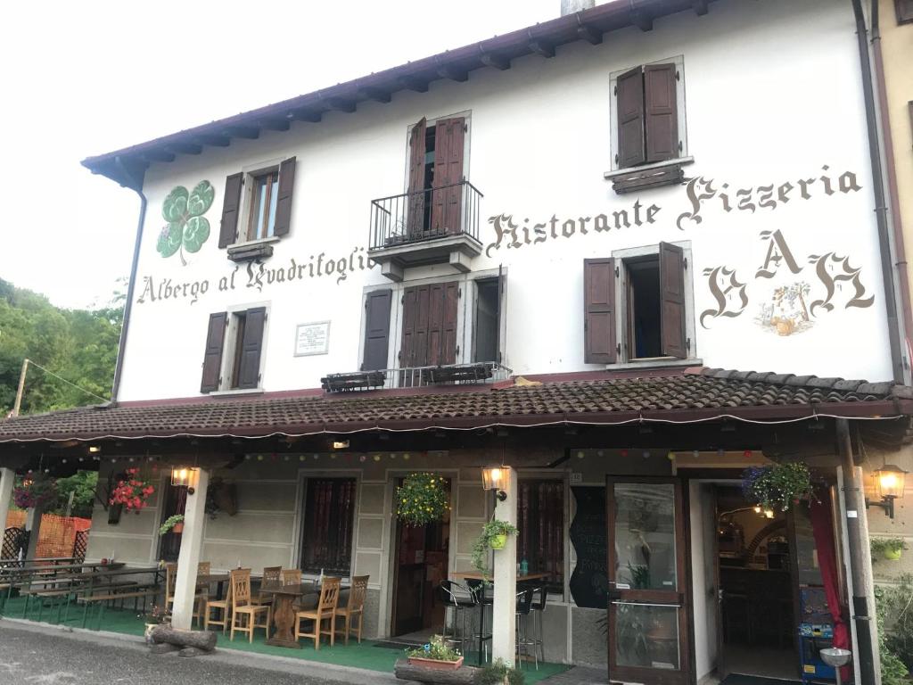a white building with a restaurant in front of it at Al Quadrifoglio in Chiaulis