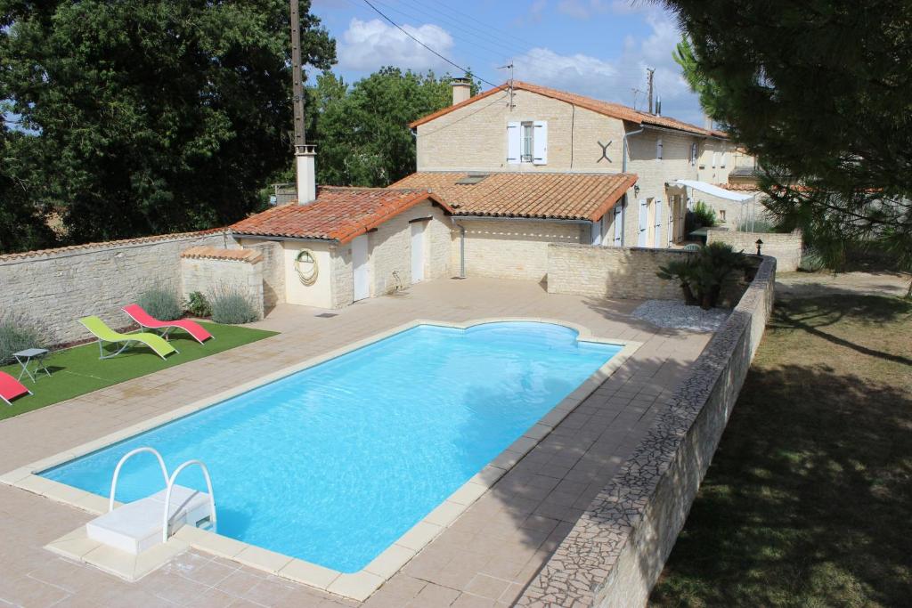 una grande piscina di fronte a una casa di Gites la Marquise a La Charrière