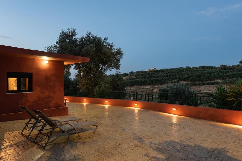 patio z krzesłem siedzącym na dachu domu w obiekcie Agapi's Home w mieście Roussospítion