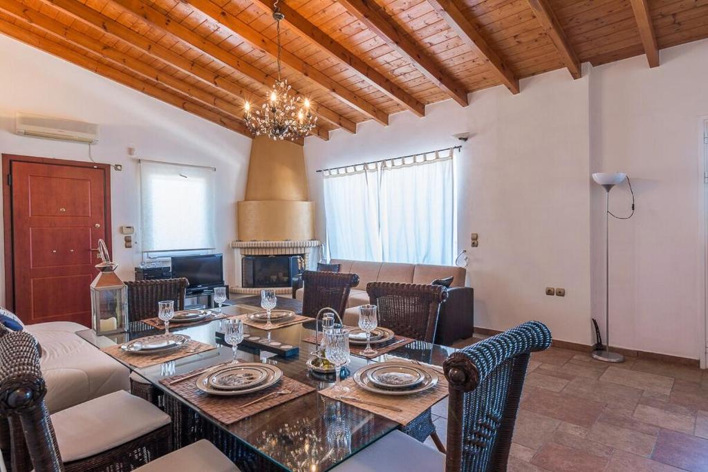 a dining room with a table with chairs and a fireplace at HOUSE NEXT TO THE SEA in Ermioni