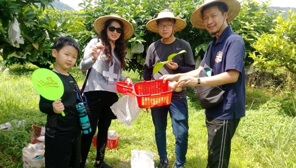 uma família posando para uma foto com um cesto em Green Ozland B&B em Dongshan