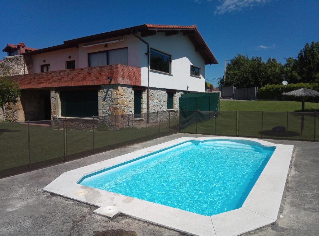 a swimming pool in front of a house at El Mazo Meruelo in San Miguel de Meruelo