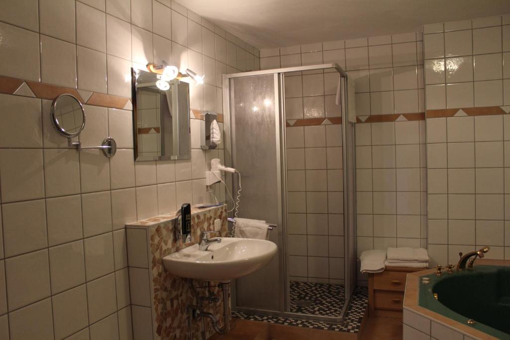 W łazience znajduje się umywalka i prysznic. w obiekcie Hotel Gardenia w mieście Reiskirchen