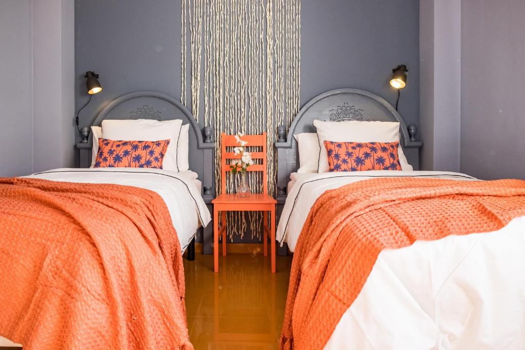 duas camas num quarto com cobertores laranja e branco em Apartamento Coral em Denia