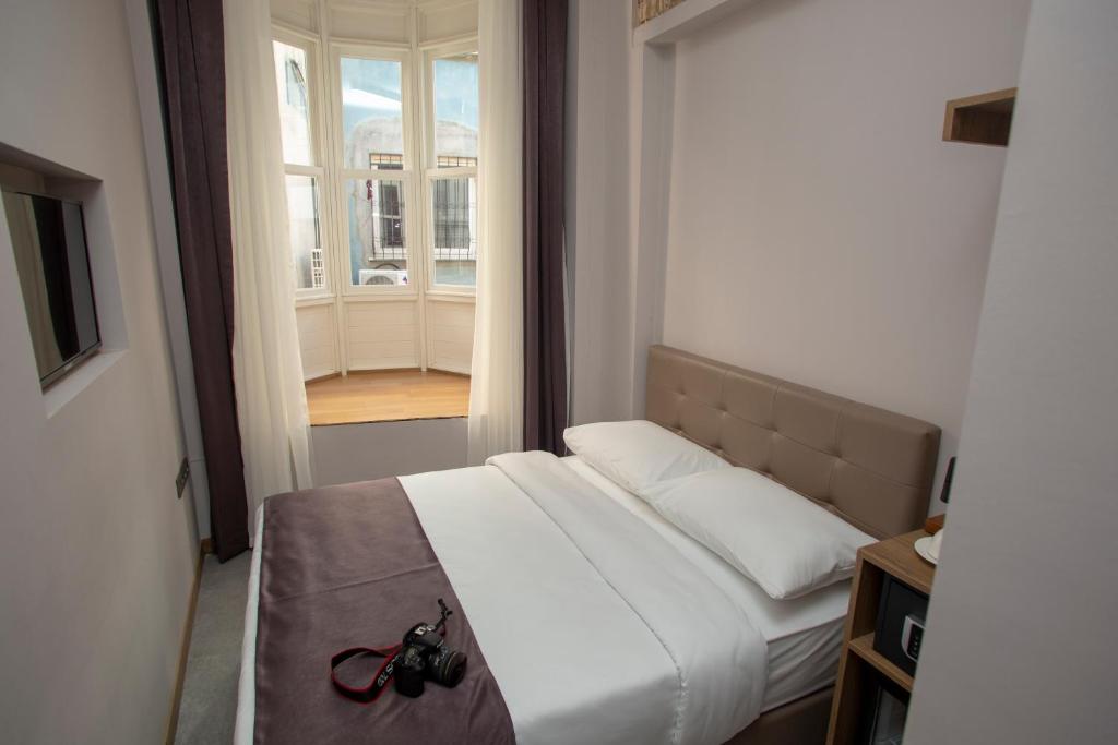 Un dormitorio con una cama con un par de gafas. en Jurnal Hotel en Estambul