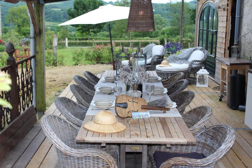 una mesa de madera con sillas en el patio en Dependance, en Youx