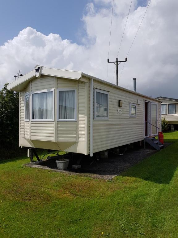 盧港的住宿－Caravan Willerby Gold Star，移动房屋停放在庭院内