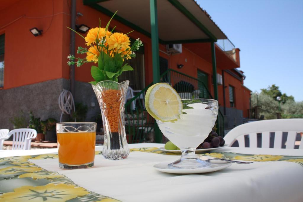 einen Tisch mit einem Getränk und eine Vase mit einem Stück Zitrone in der Unterkunft B&B Borgo Pileri in Mazzarino