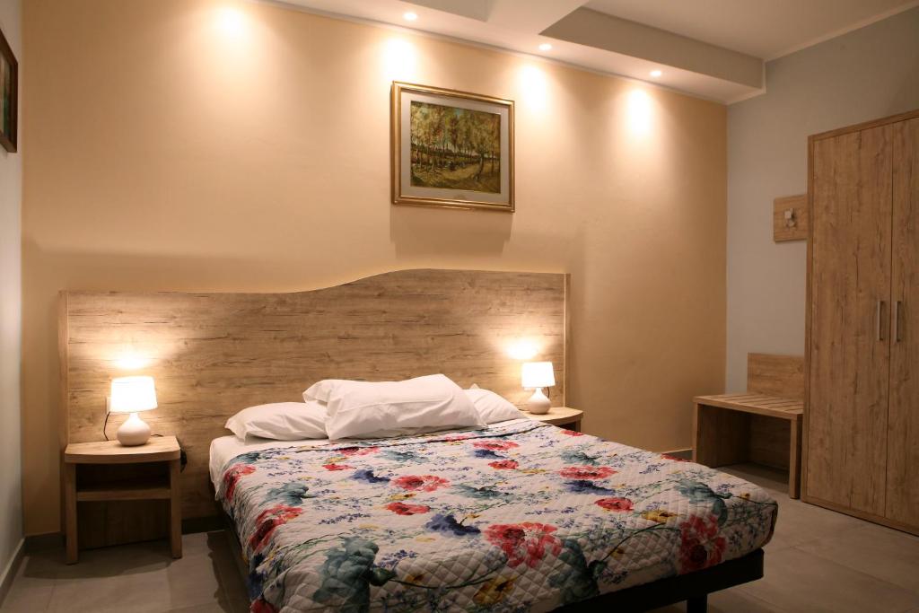 1 dormitorio con 1 cama y 2 lámparas en 2 mesas en La casa di nonno Giulio, en Porto SantʼElpidio