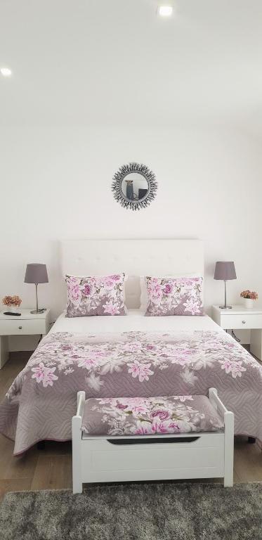 a bedroom with a white bed with pink flowers at Old Dream in Nazaré