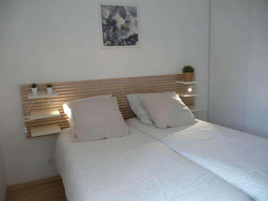 un letto bianco con due cuscini in una camera da letto di Eric's Appartement -Charmant T2 - a Cambo-les-Bains