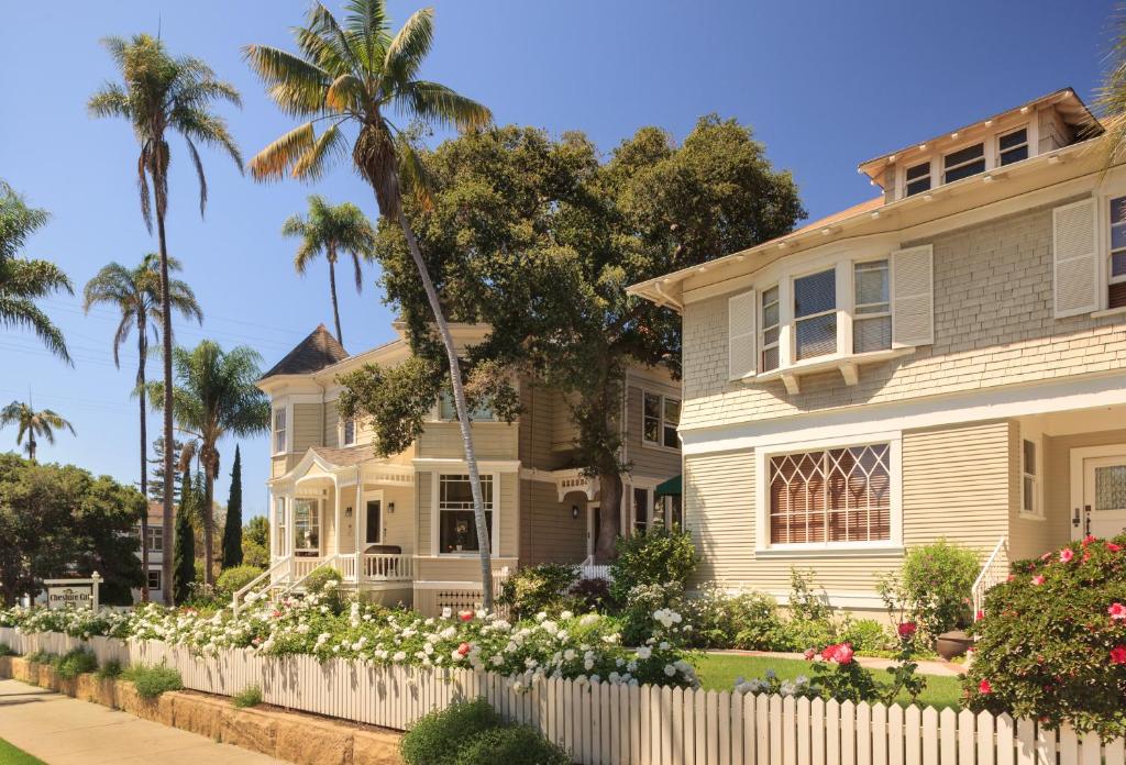 ein Haus mit einem weißen Zaun und Blumen in der Unterkunft Cheshire Cat Inn & Cottages in Santa Barbara