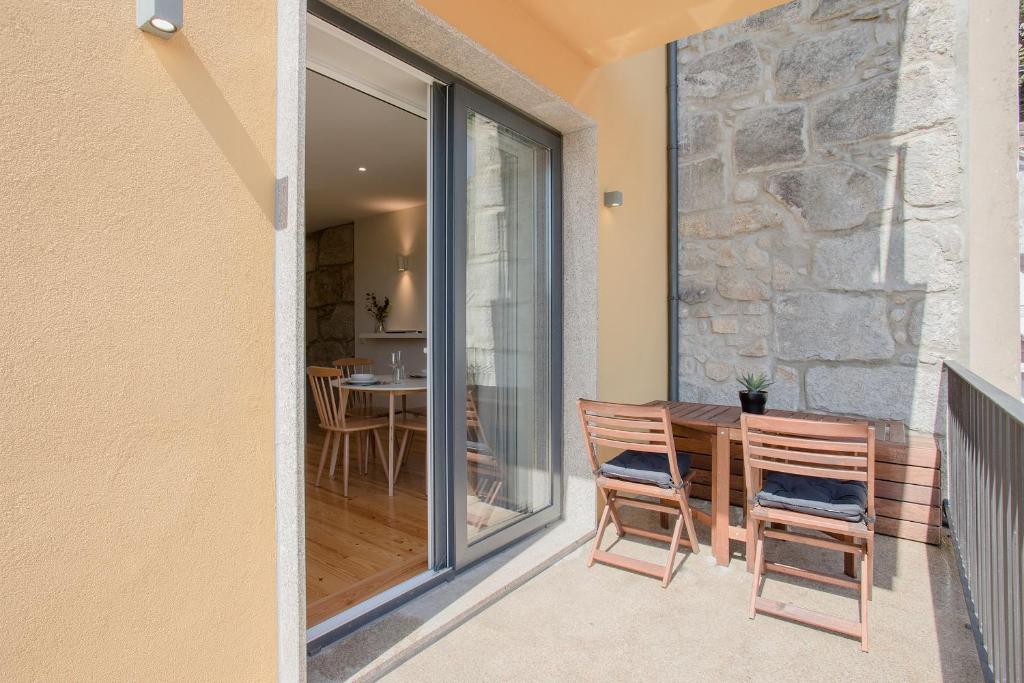 een patio met 2 stoelen en een tafel op een balkon bij Liiiving in Porto - Charming Downtown Delight in Porto