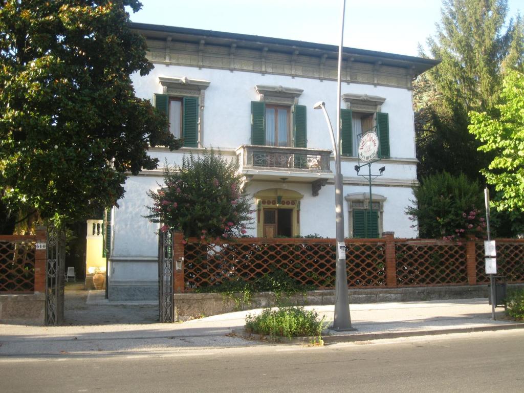 une maison blanche avec une clôture devant elle dans l'établissement Villa Patrizia B&B, à Lucques
