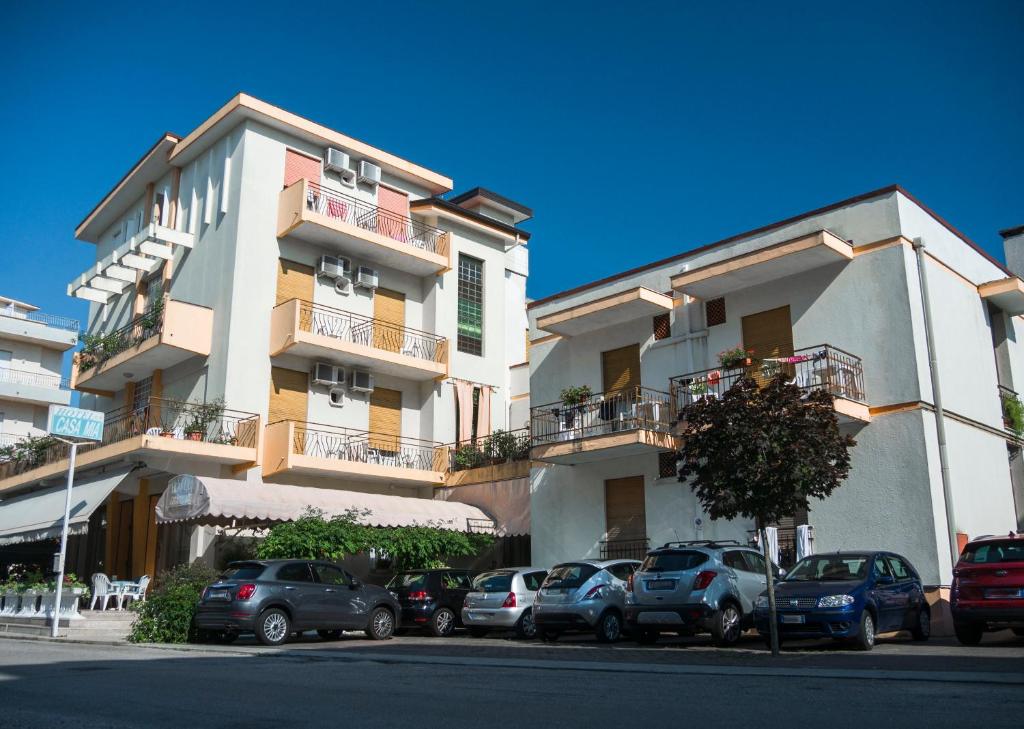 un groupe de voitures garées devant un bâtiment dans l'établissement Hotel Casa Mia, à Lido di Jesolo