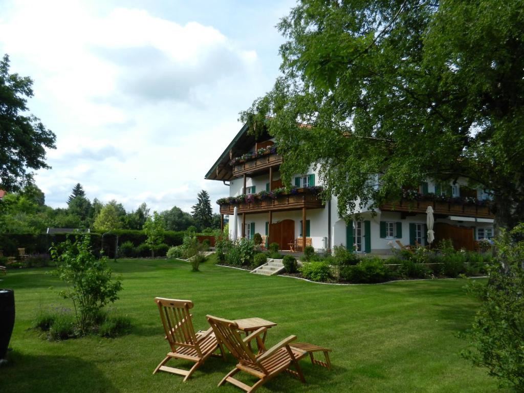 una casa con sillas de jardín delante de ella en Landhaus Marinella Hotel Garni, en Bad Wiessee